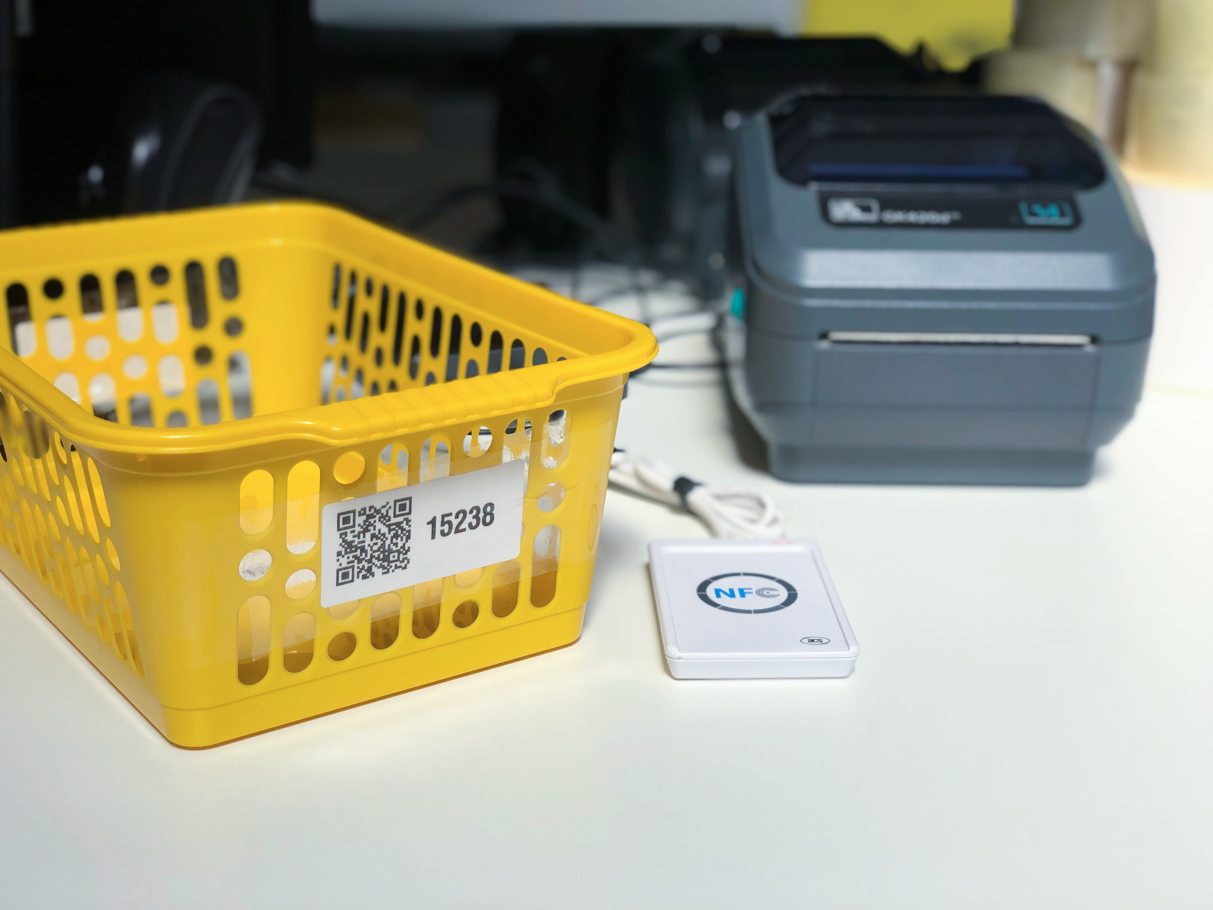 A basket with a barcode on it, an NFC touch pad and a thermal printer